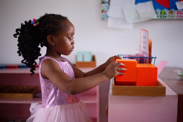 Pupil with Montessori golden bead blocks